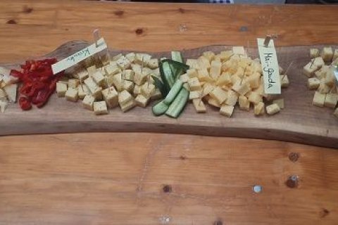 verschiedene K&auml;sesorten in W&uuml;rfelform auf einem Holzbrett