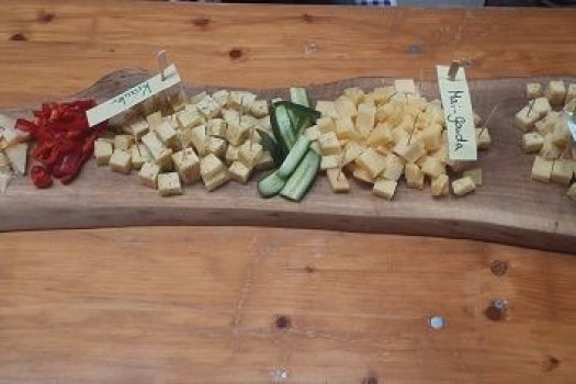 verschiedene K&auml;sesorten in W&uuml;rfelform auf einem Holzbrett