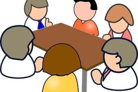 Bild von einer Gruppe Menschen am Tisch