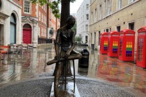 Foto von Figur in England mit Telefonzellen im Hintergrund