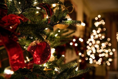 Ausschnitt eines Weihnachtsbaums mit roten Kugeln und roten Samtschleifen