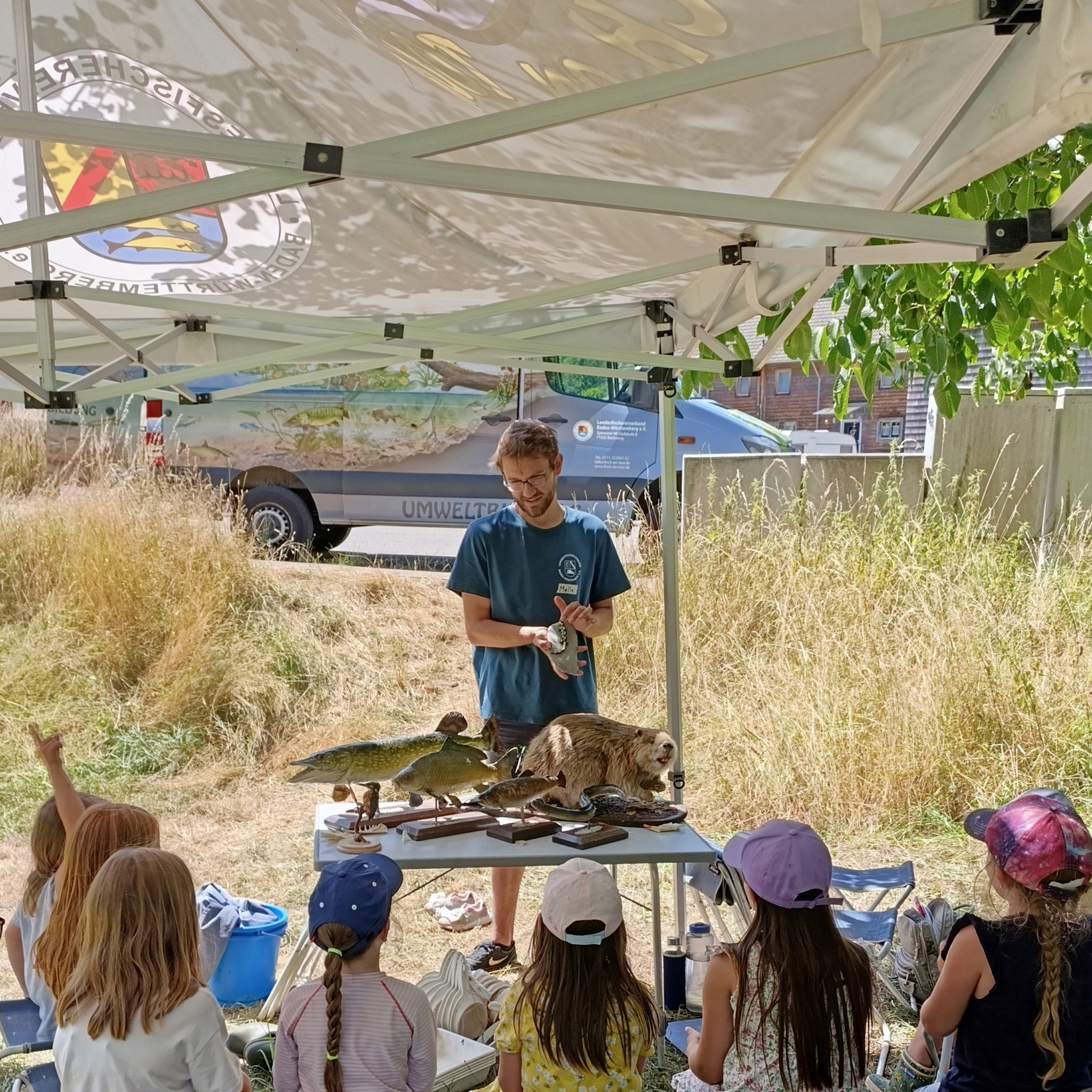 Eine Gruppe von Kindern während des Kurses vor dem Fischmobil.
